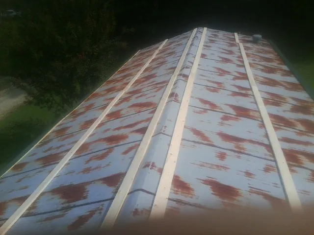 Rusted metal roof panels with new wood purlins before replacement — Storm Damage Roof Repair in Emerado by Roofing Brothers