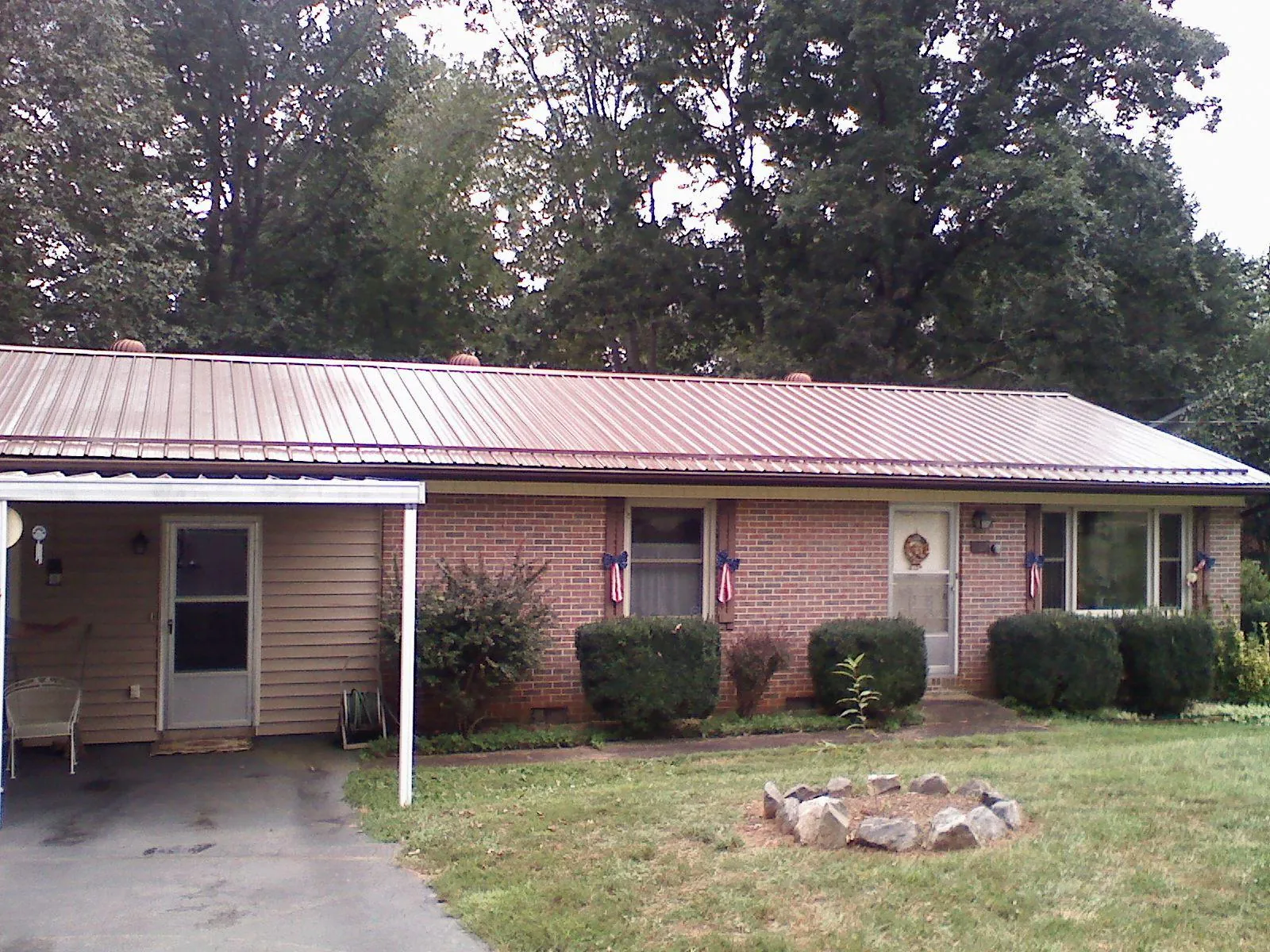 Bronze metal roof and carport on a brick ranch home — Roof Repair work by our crew in Emerado
